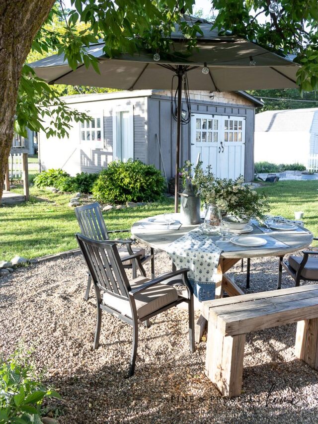 ambiance, backyard, beautiful, beautiful backyard, beauty, borders, chairs, cottage, cottage home, cottage home exterior, cottage style, diy, diy outdoor projects, diy projects, english cottage style, fence, fire, fire pit, flower beds, flower boxes, flower garden, flowers, gardens, hammock, Home exterior, inspiration, lighting, low maintenance plants, natural, neutral, outdoor dining, outdoor seating, outdoor space, Outdoors, patio, pea gravel patio, Plants, rock border, rocks, stone, stone border, string lights, vegetable garden, white picket fence, wood, wood fence