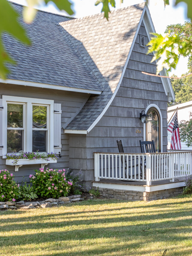 black rockers, charm, cottage style, cottage style curb appeal, cottage style front yard, curb appeal, deck, entryway, flowers, front door, Front Porch, front yard, Home Accents, lantern, outdoor decor, Outdoor Entryway, outdoor lighting, outdoor plants, outdoor seating, Outdoors, paint, patio, Planters, Plants, Porch, round storm door, spring, stain, stone, storm door