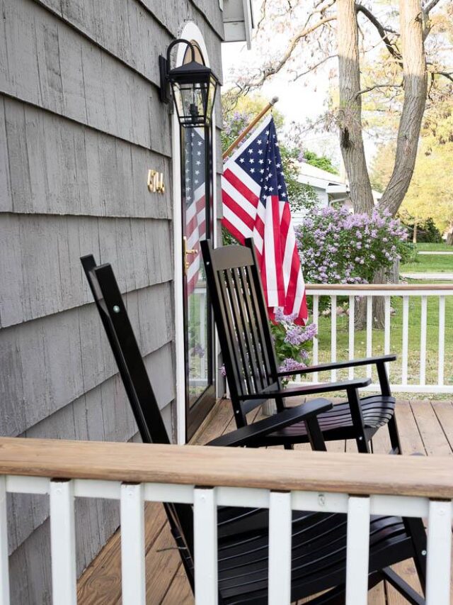 black rockers, charm, cottage style, cottage style curb appeal, cottage style front yard, curb appeal, deck, entryway, flowers, front door, Front Porch, front yard, Home Accents, lantern, outdoor decor, Outdoor Entryway, outdoor lighting, outdoor plants, outdoor seating, Outdoors, paint, patio, Planters, Plants, Porch, round storm door, spring, stain, stone, storm door